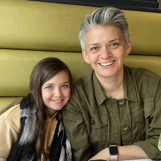 Photo of Ingrid Steward and her daughter on a yellow/green sofa.