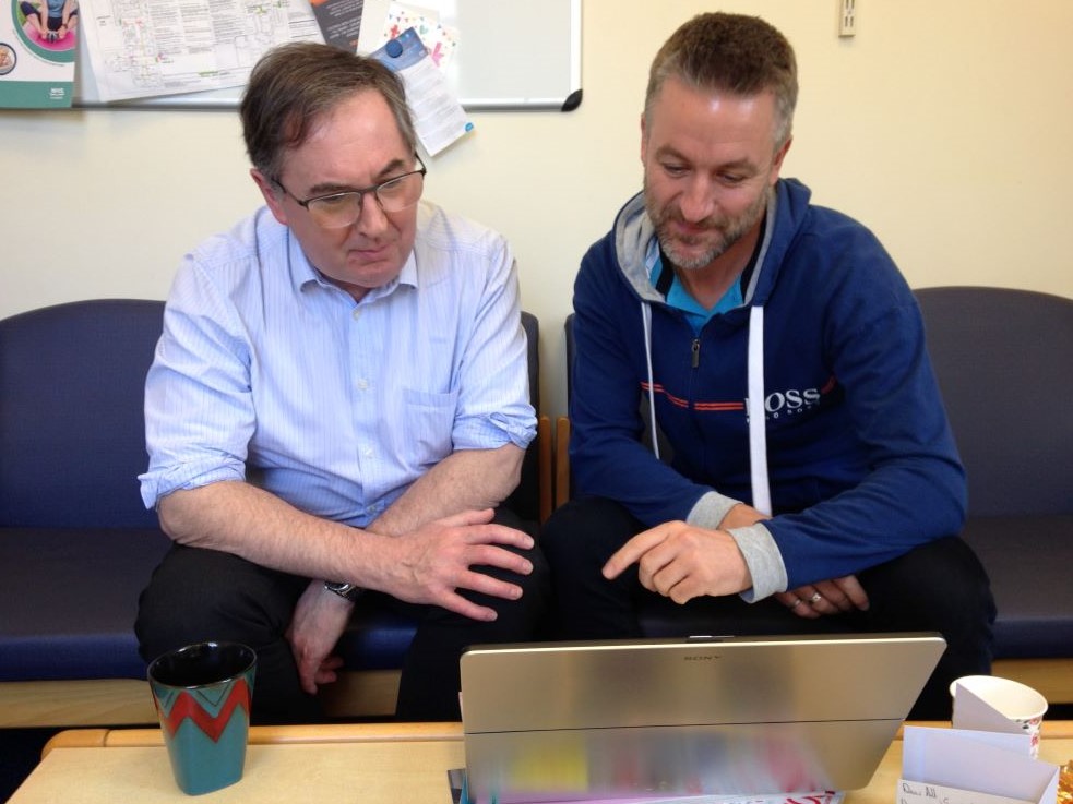 Jim and John Dean in meeting looking at laptop